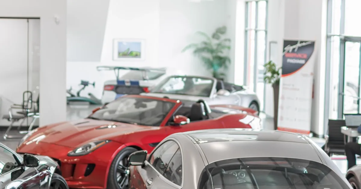 Stand automóvel com viaturas expostas e ecrã a mostrar listagem de carros online